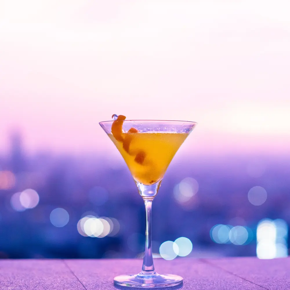 Oranger Drink vor pinkem Hintergrund.